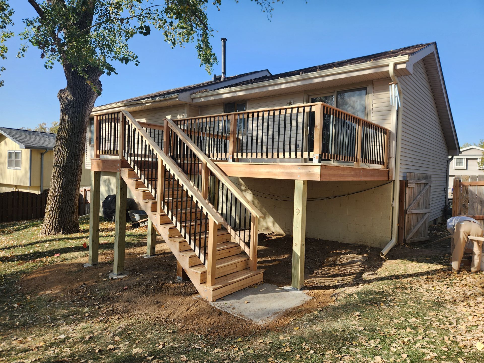 A house with a wooden deck and stairs in the backyard.