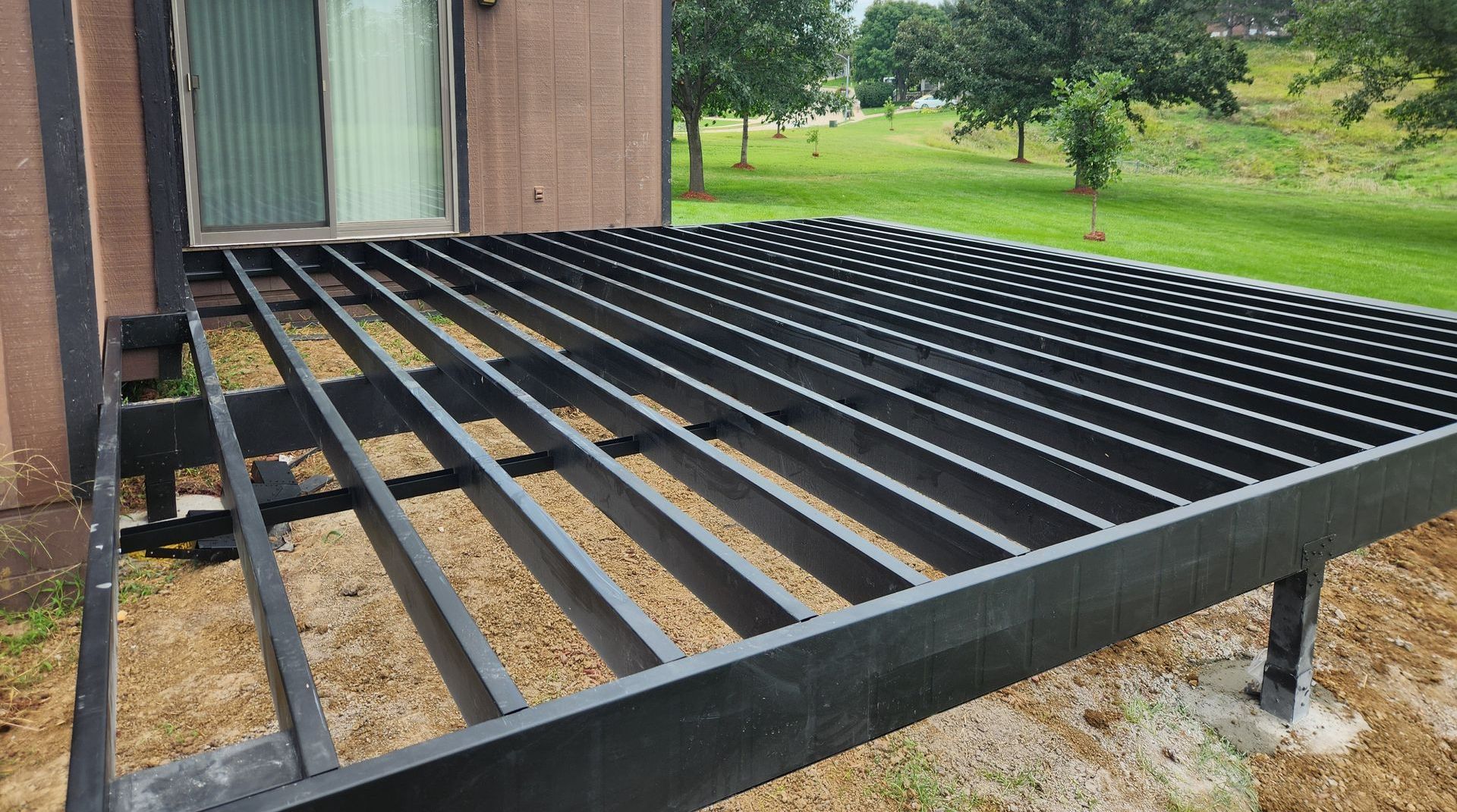 A wooden deck is being built in front of a house.