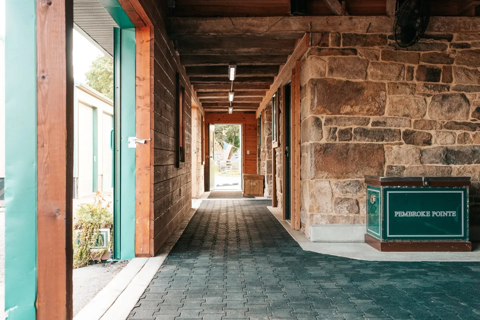 Stone walkway with wooden beams and a green sign.