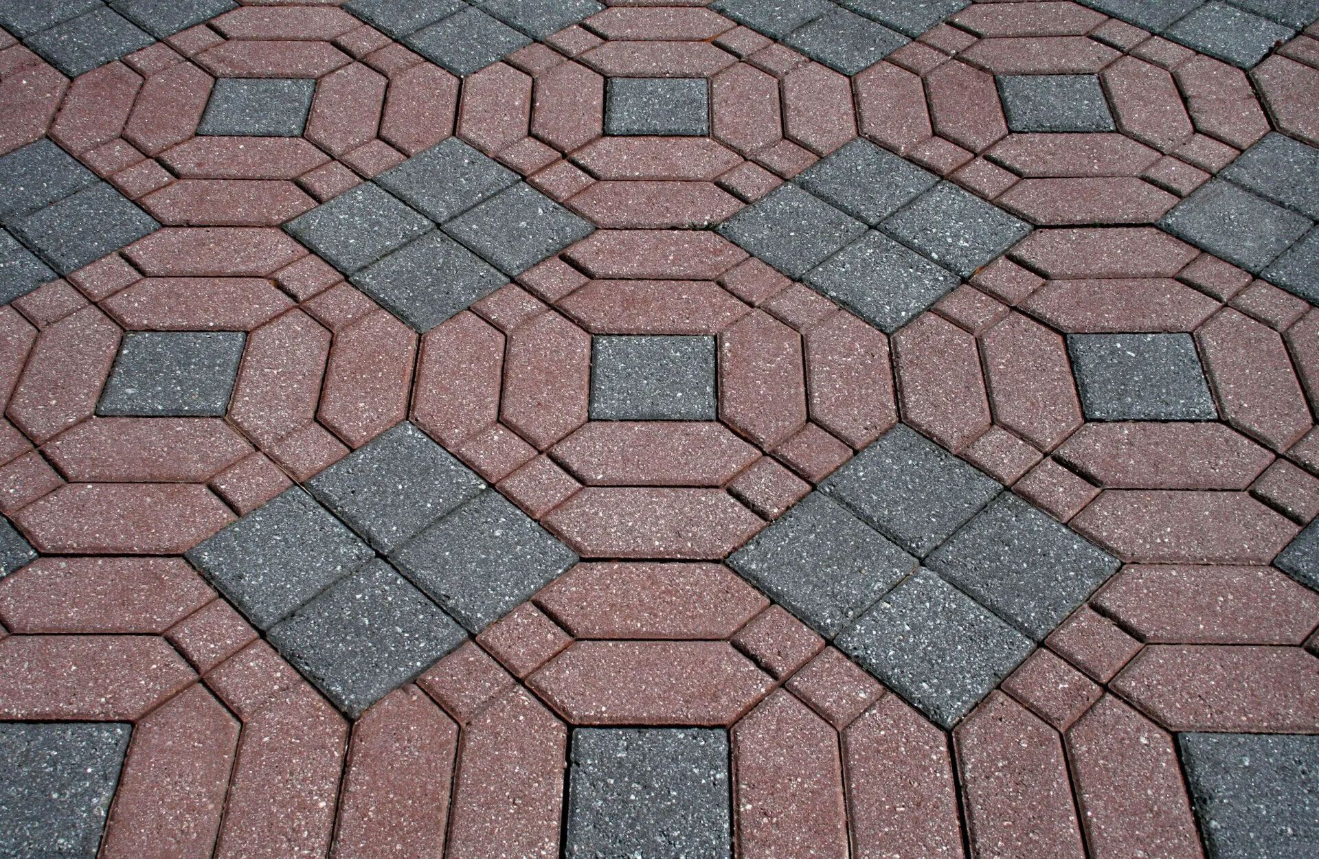 Red and gray brick paving stones in a repeating geometric pattern.