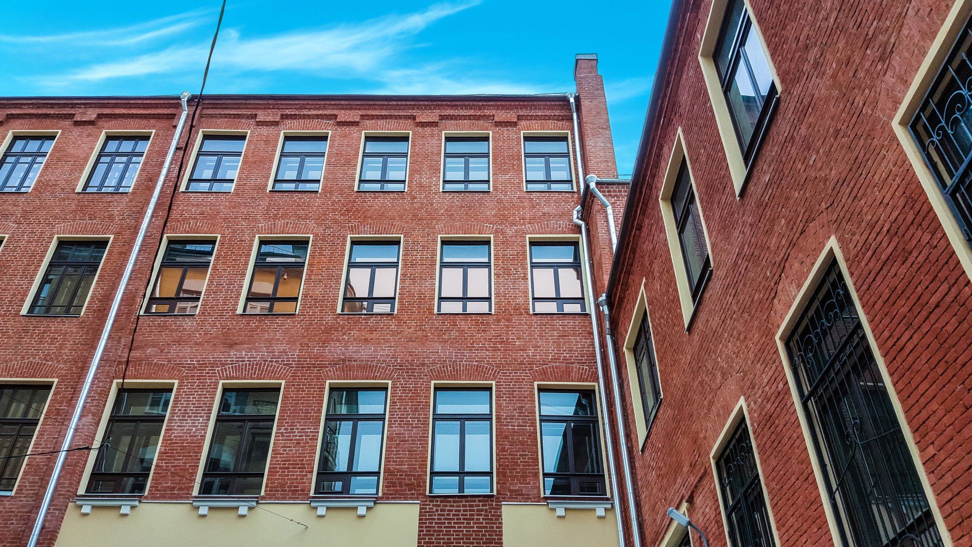 A brick building with a lot of windows and a blue sky in the background