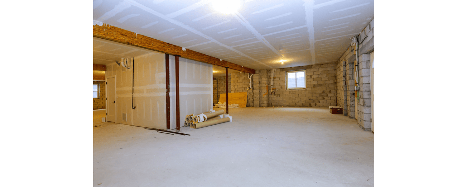 Interior view of an unfinished basement with drywall, exposed beams, and concrete flooring.