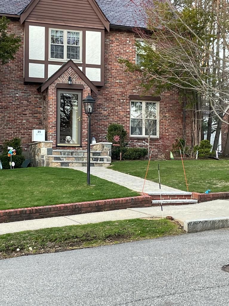 Brick house with a green lawn and walkway to the front door.