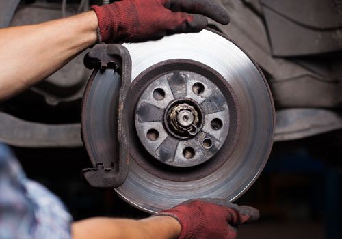 A person is fixing a brake disc on a car.