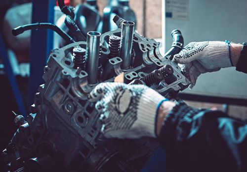 A man is working on a car engine in a garage.