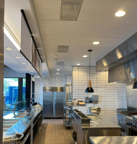 Interior of a Chipotle kitchen, stainless steel counters, refrigerator, and cooking equipment.