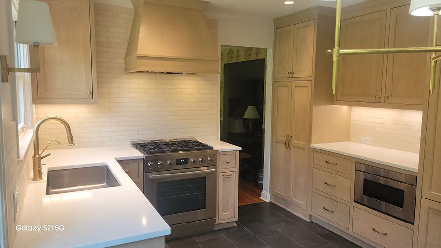 Newly remodeled kitchen with light wood cabinets, stainless steel appliances, and white countertops.
