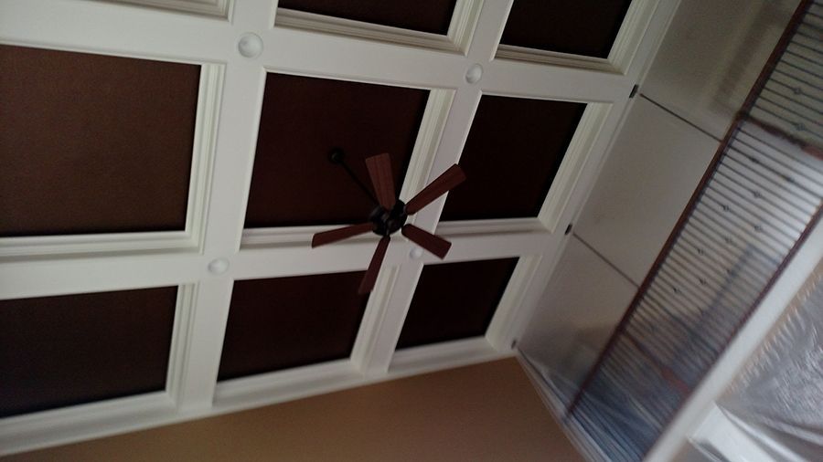 Brown and white coffered ceiling with a ceiling fan.