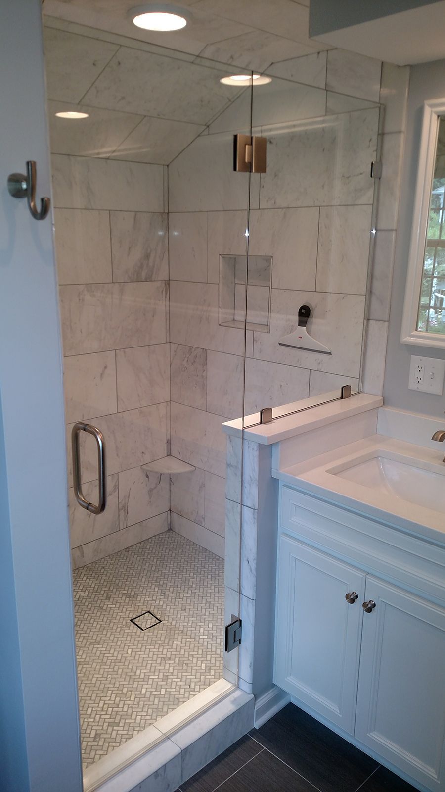 Modern bathroom with a glass shower enclosure and white vanity.