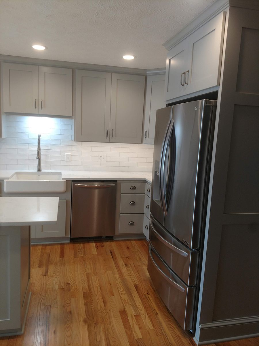 Gray and white kitchen with stainless steel appliances and hardwood floors.