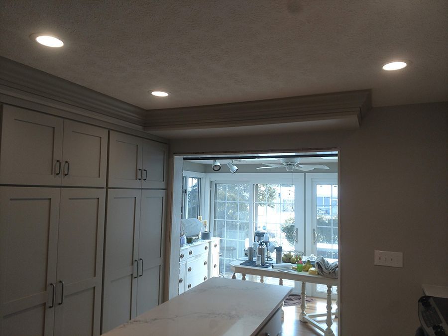 Kitchen with gray cabinets and a countertop island. A window leads to an outdoor patio area.