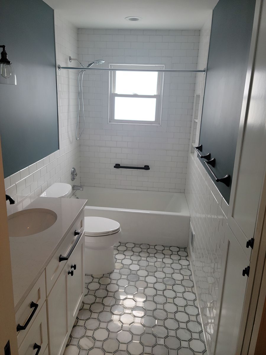 Bathroom with white and gray hexagon tile floor, white subway tile wall, dark blue accent walls, and white vanity.