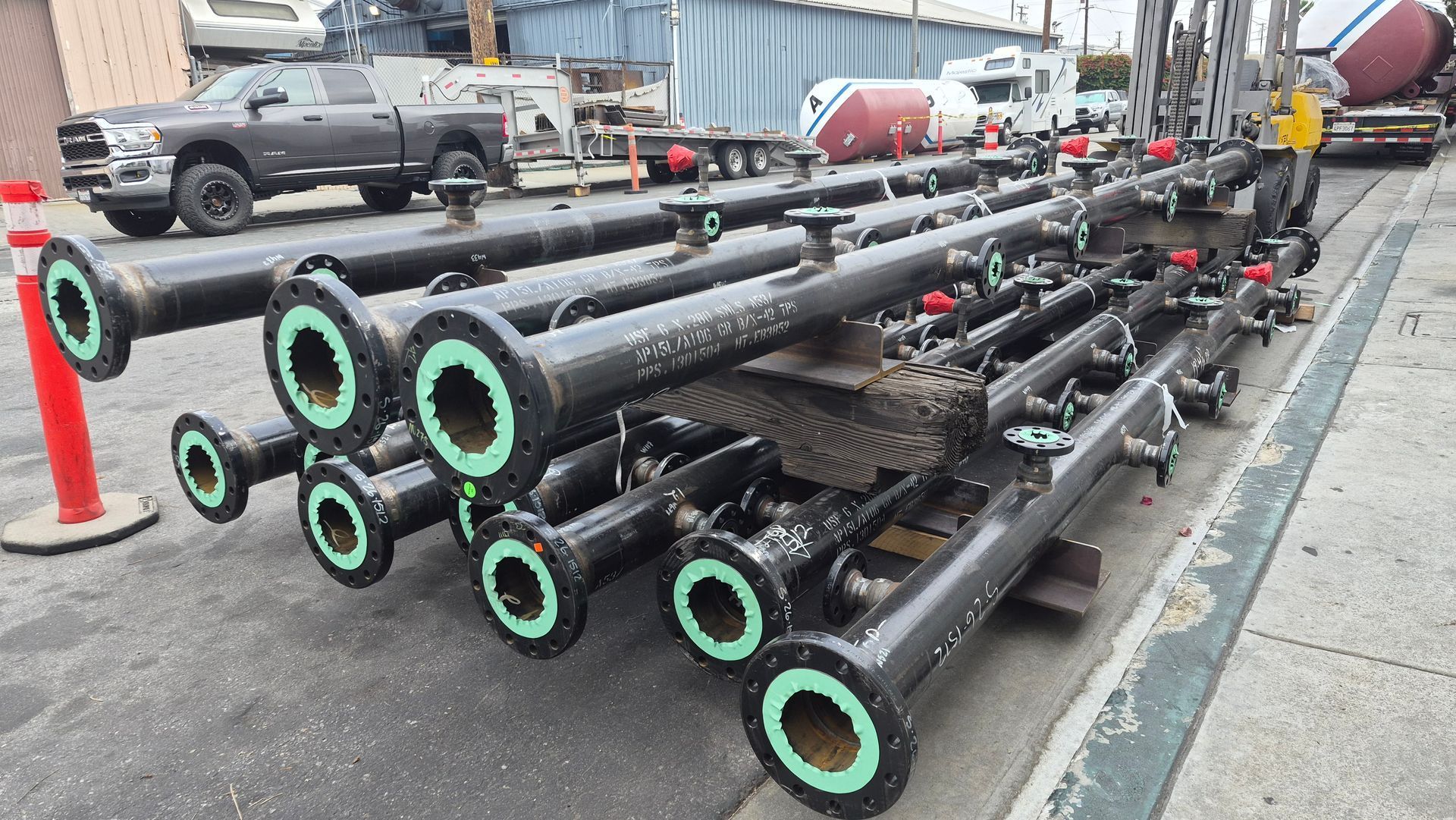 Stacked black metal pipes with green ends