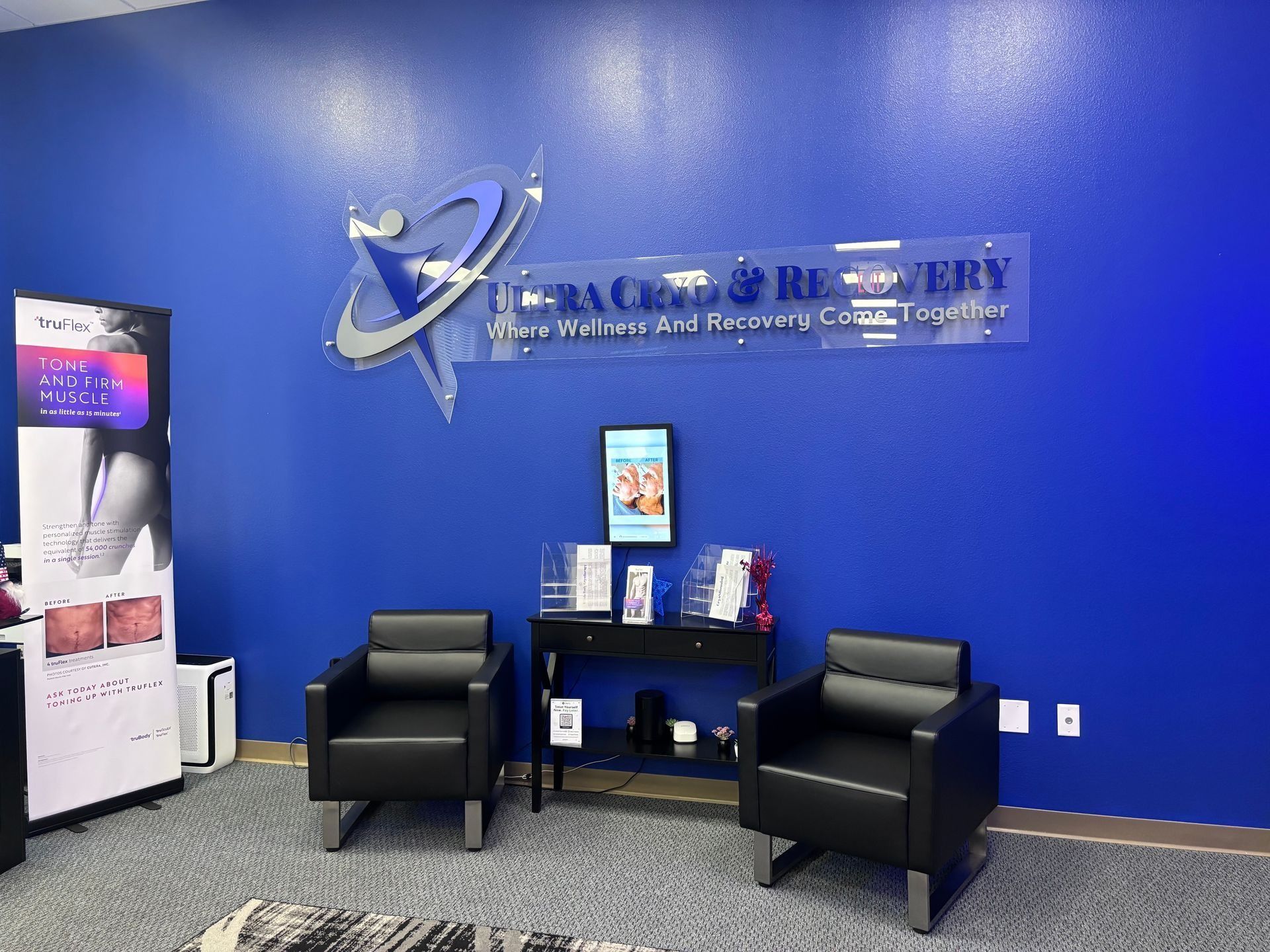 Lobby with blue wall, Terra Care & Recovery sign, two black chairs, and a small table with brochures.