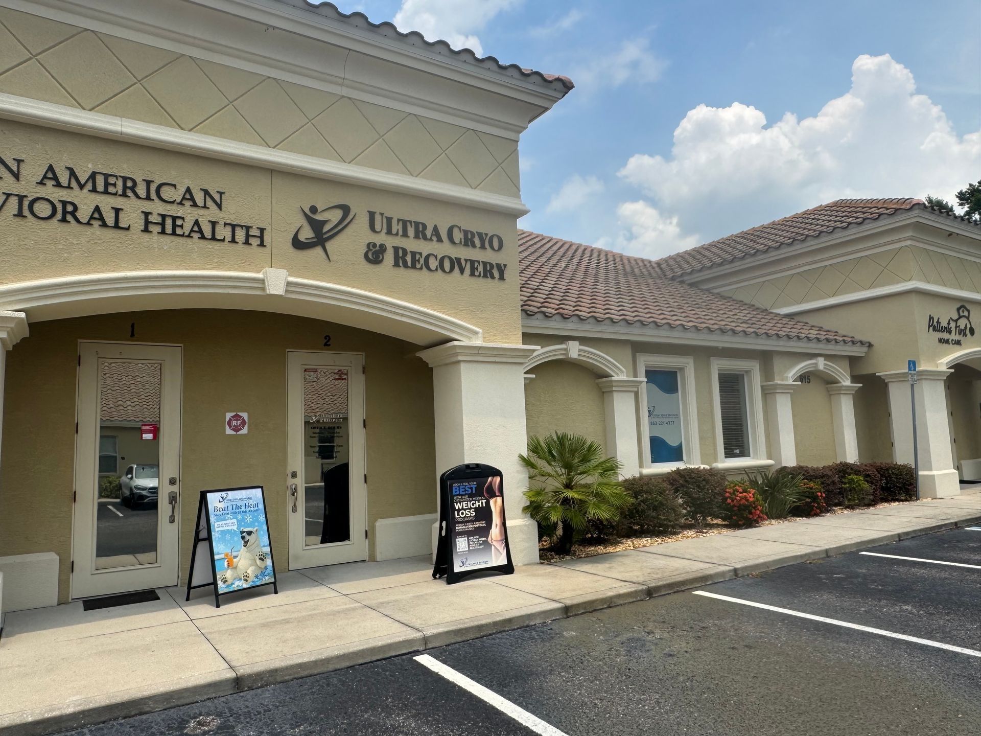 Building exterior: American Behavioral Health & Ultra Cure & Recovery. A-frame signs, entrance doors, and windows.