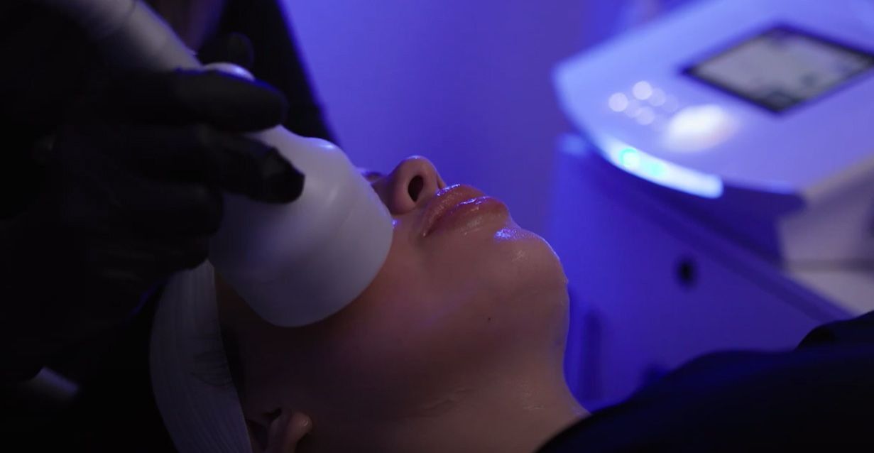 Person receiving facial treatment with a light device in a spa.