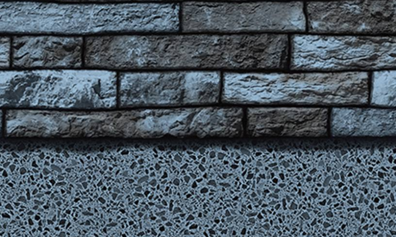 Blue-gray stone wall above a speckled concrete base