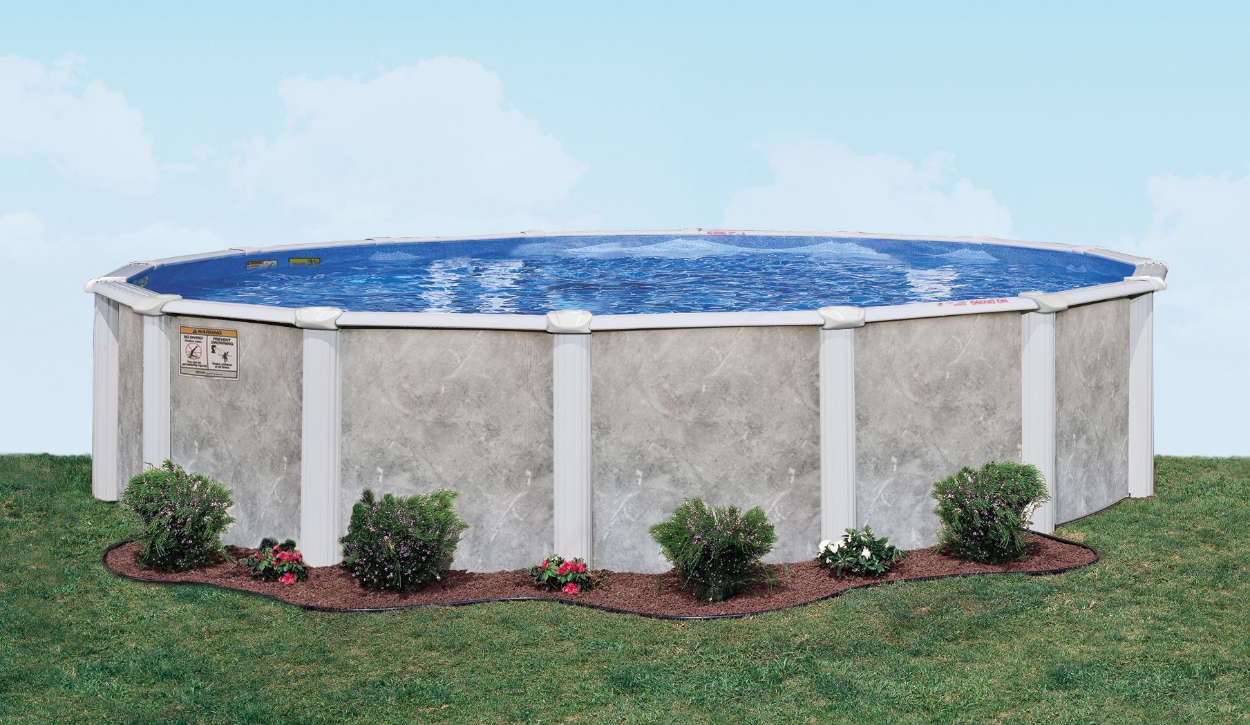 Round above-ground pool with blue water, white walls, and small shrubs around it on grass.