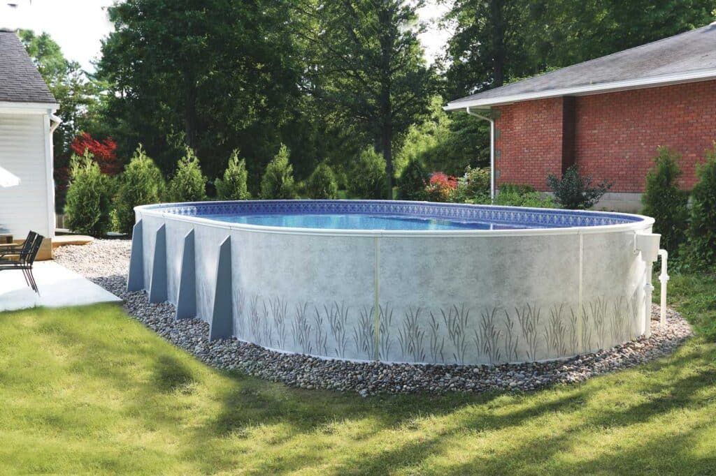 Above-ground backyard pool with blue water, surrounded by grass and a brick house.