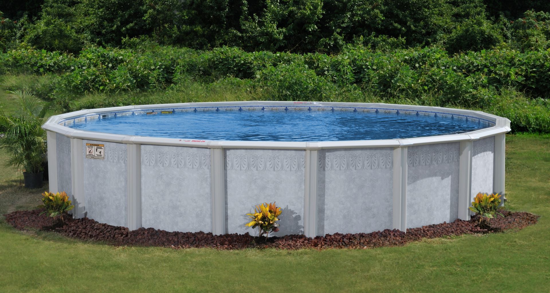Round above-ground swimming pool in a grassy backyard with blue water and white sides