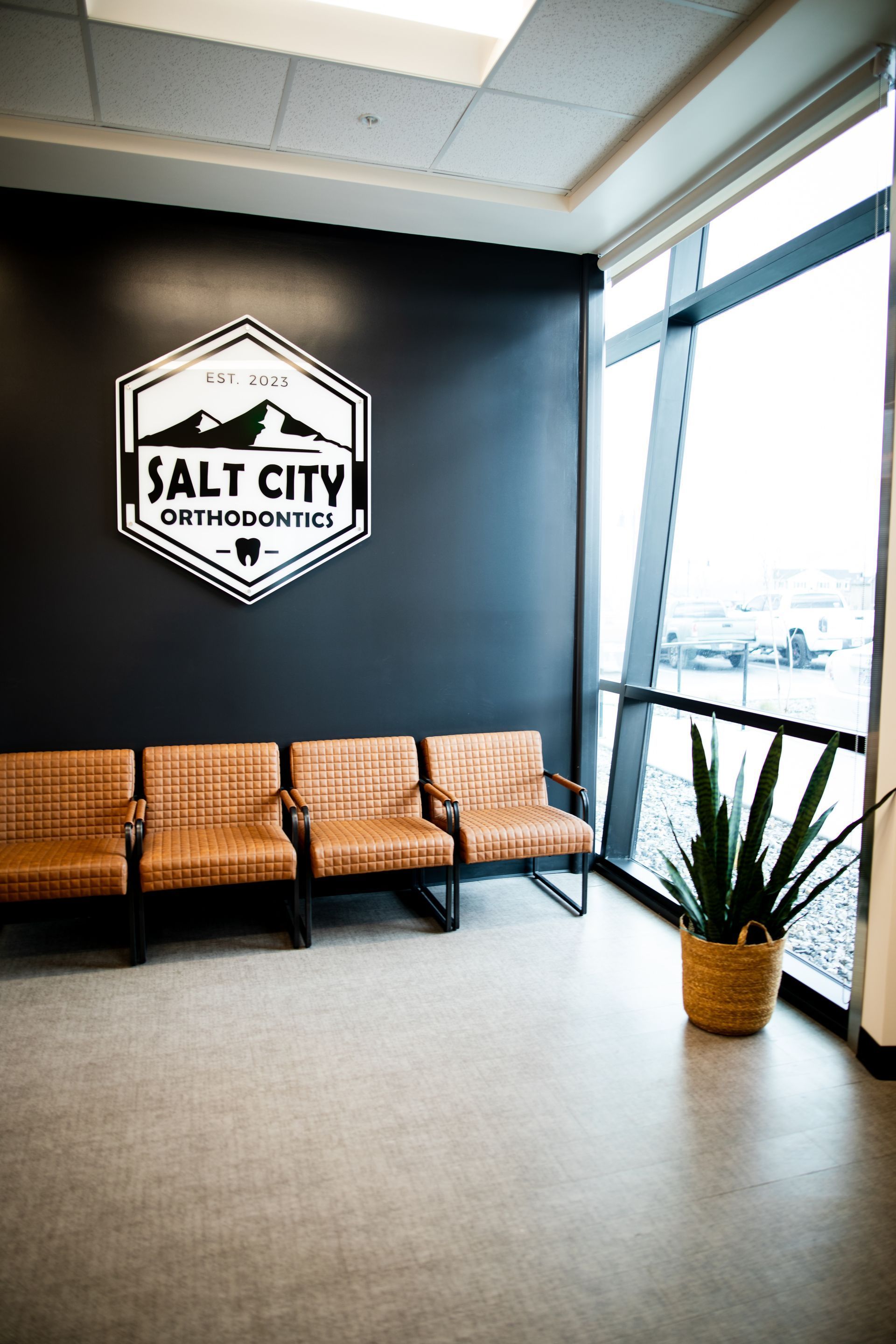A waiting room with chairs and a sign that says salt city orthodontics.
