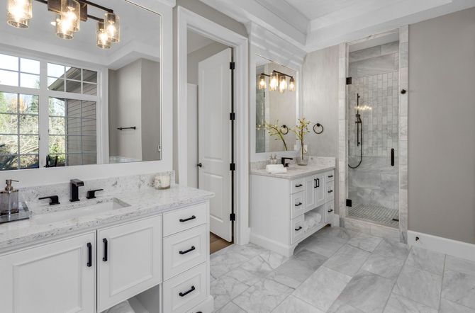 A bathroom with two sinks and a walk in shower.