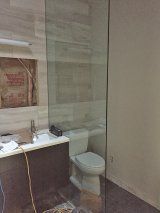 A bathroom with a toilet , sink and walk in shower