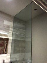 A bathroom with a glass shower door and a mirror