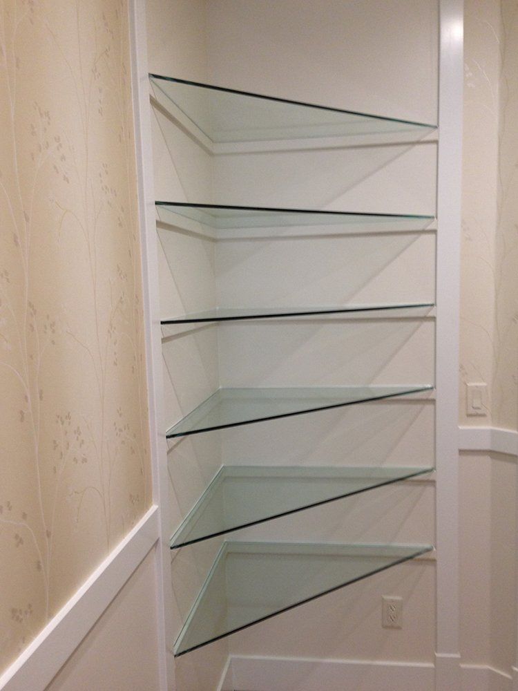 A row of glass shelves in a corner of a room
