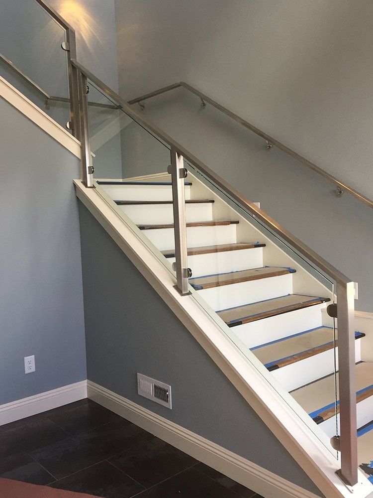 A staircase with white steps and a glass railing