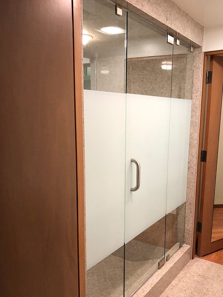 A hallway with a glass door and a wooden door