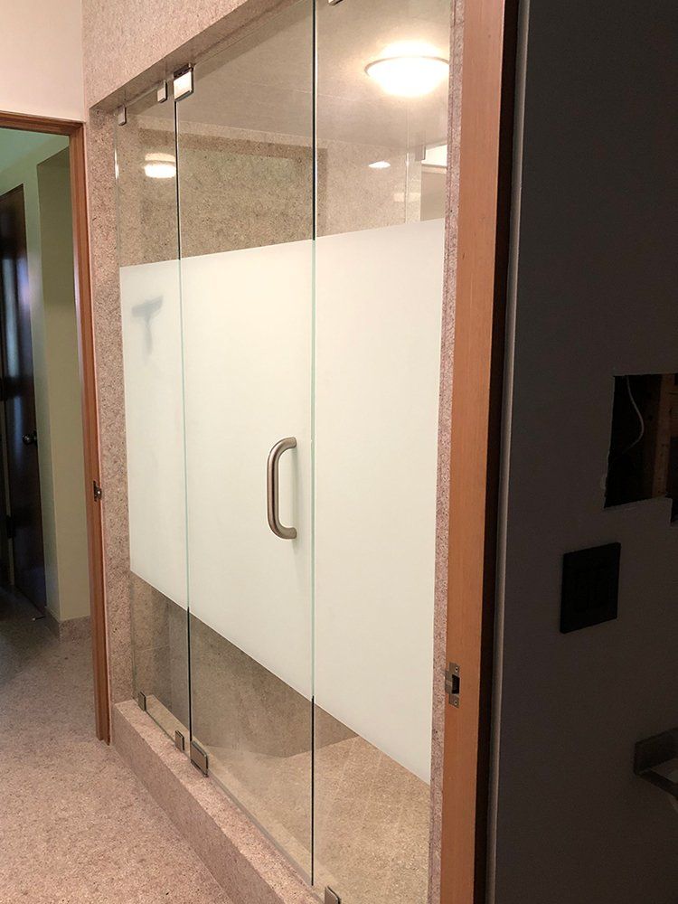 A bathroom with a glass door and a sliding glass door