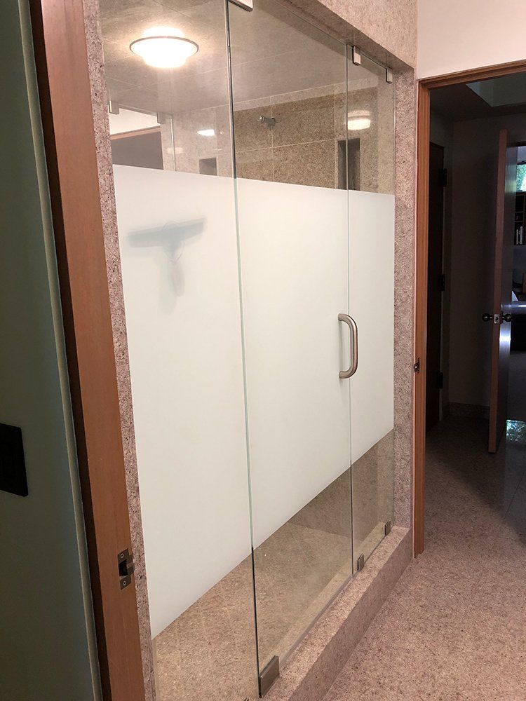 A glass door with a frosted glass film on it in a hallway