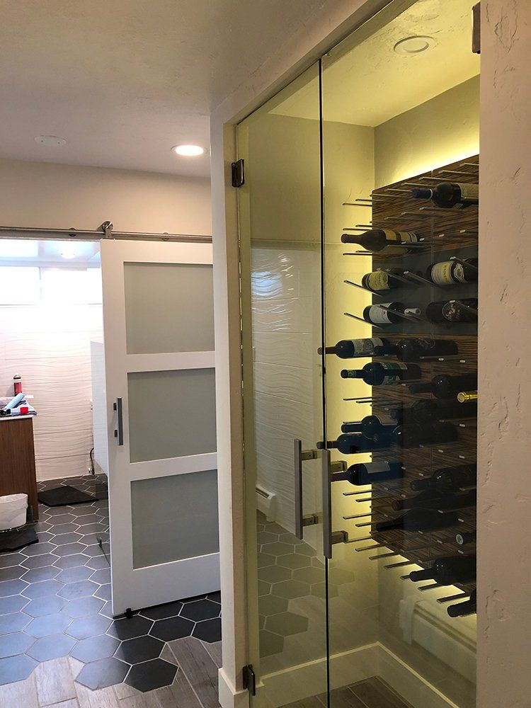 A wine cellar with a glass door filled with bottles of wine