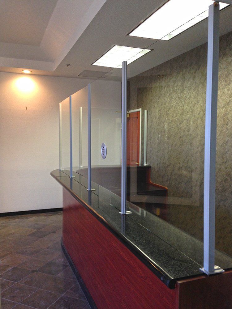 An empty lobby with a red counter and a glass divider