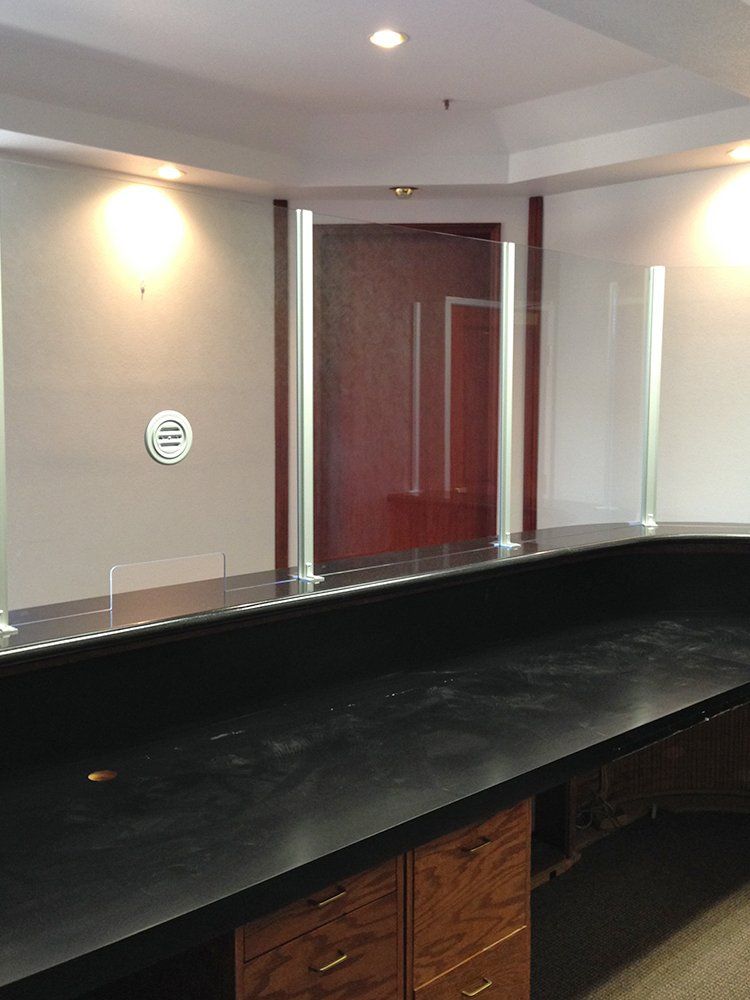 A long counter with a glass barrier between it and a door