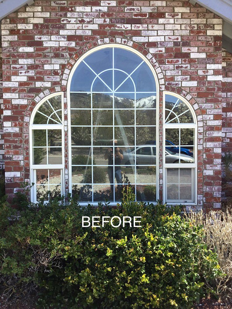 A before picture of a brick house with arched windows