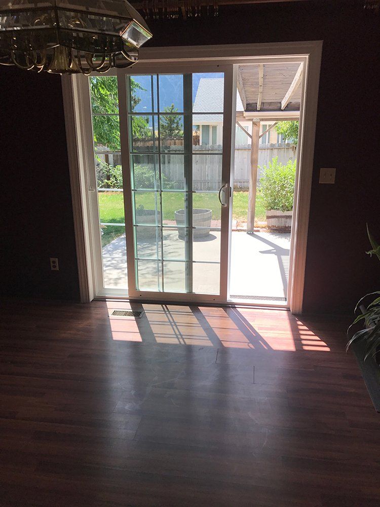 An empty room with a sliding glass door leading to a patio