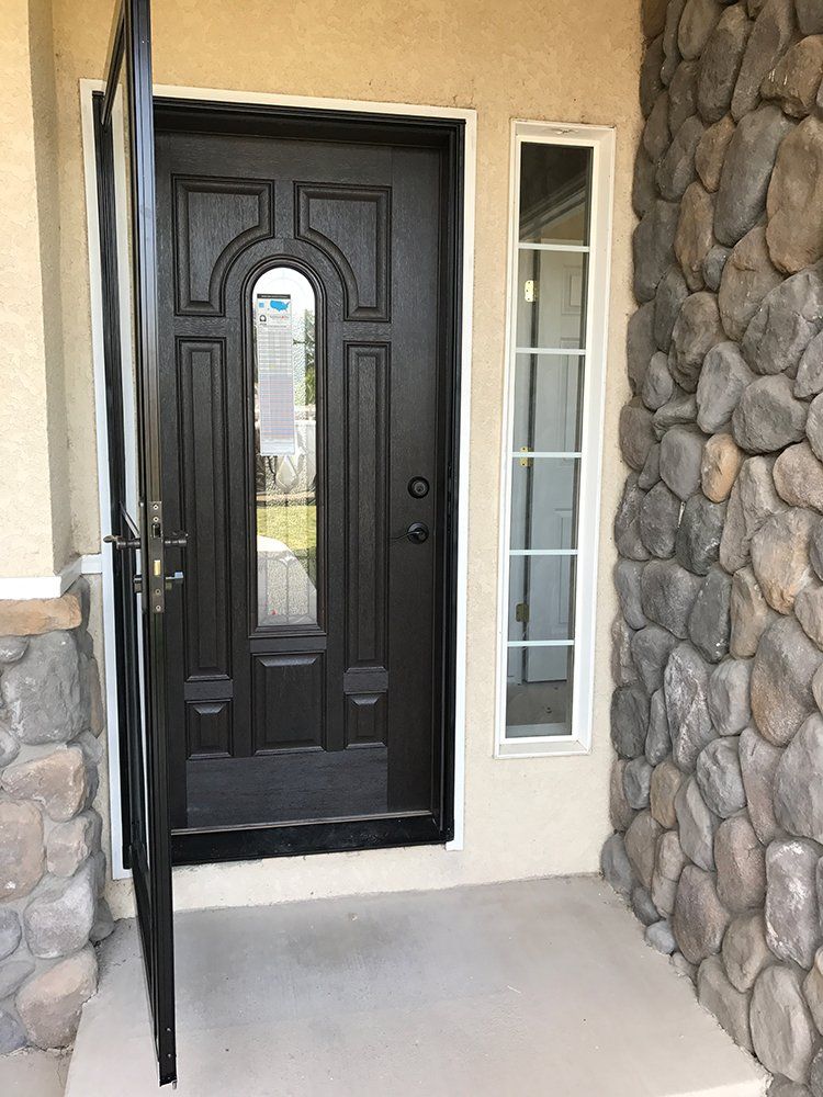 The front door of a house with a stone wall and a black door