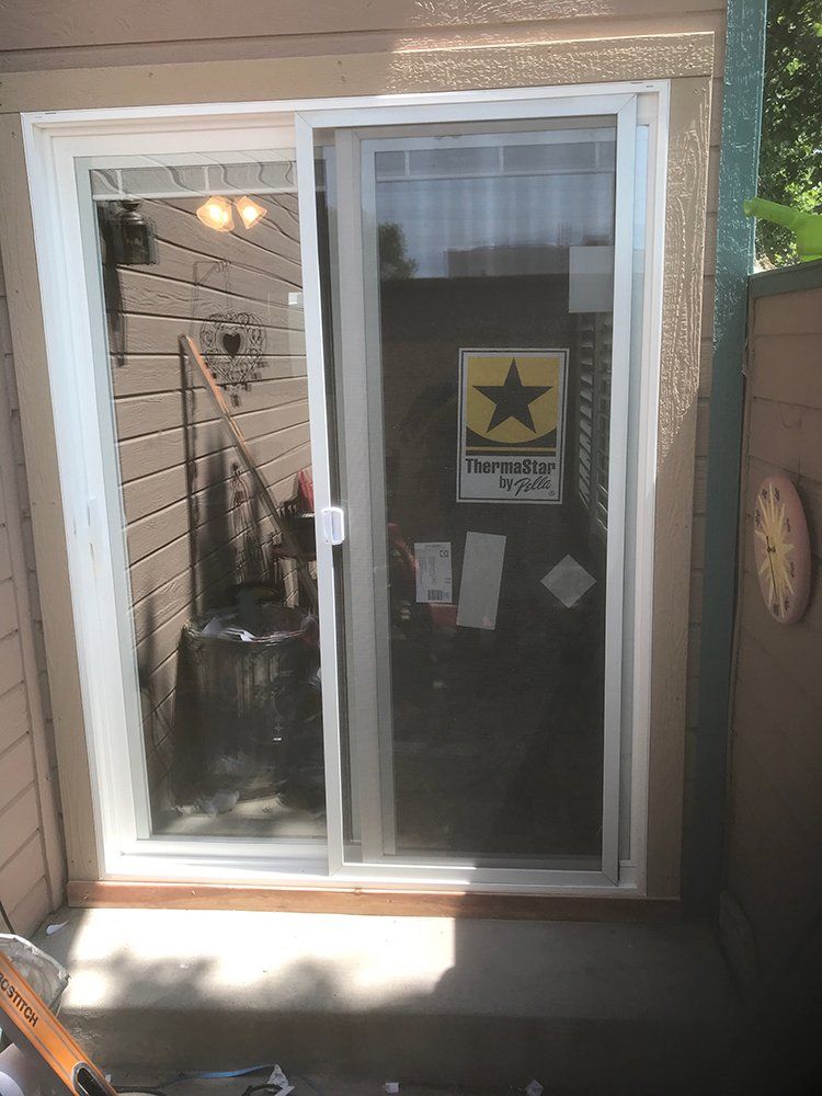 A sliding glass door with a star on it is open to a patio