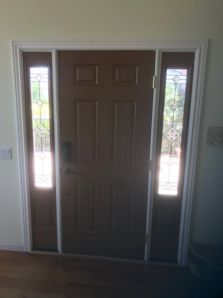 A brown front door with stained glass windows in a living room