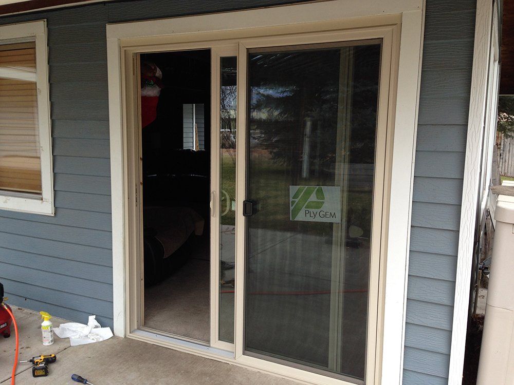 A sliding glass door is being installed on the side of a house