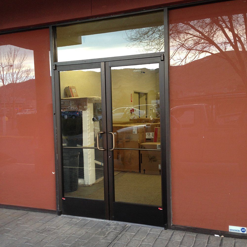 A store front with a glass door and a red wall