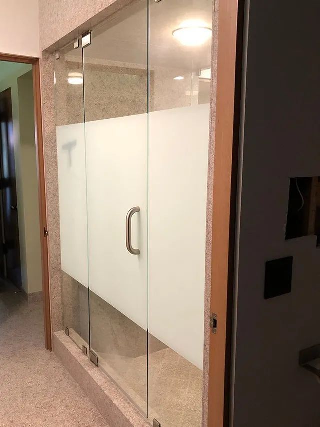 A glass door with a sliding glass door in a hallway