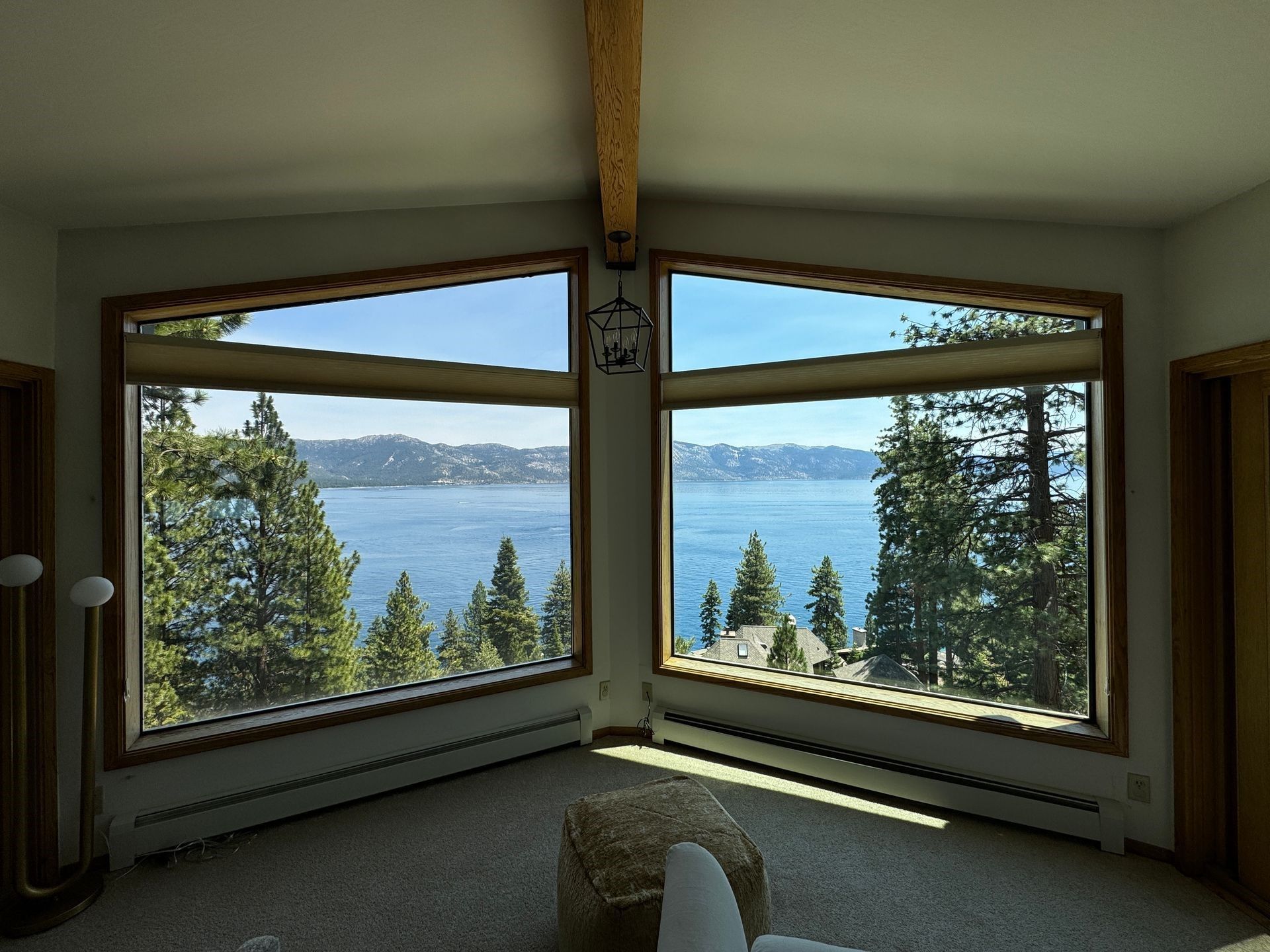 A glass window with a view of a lake and trees