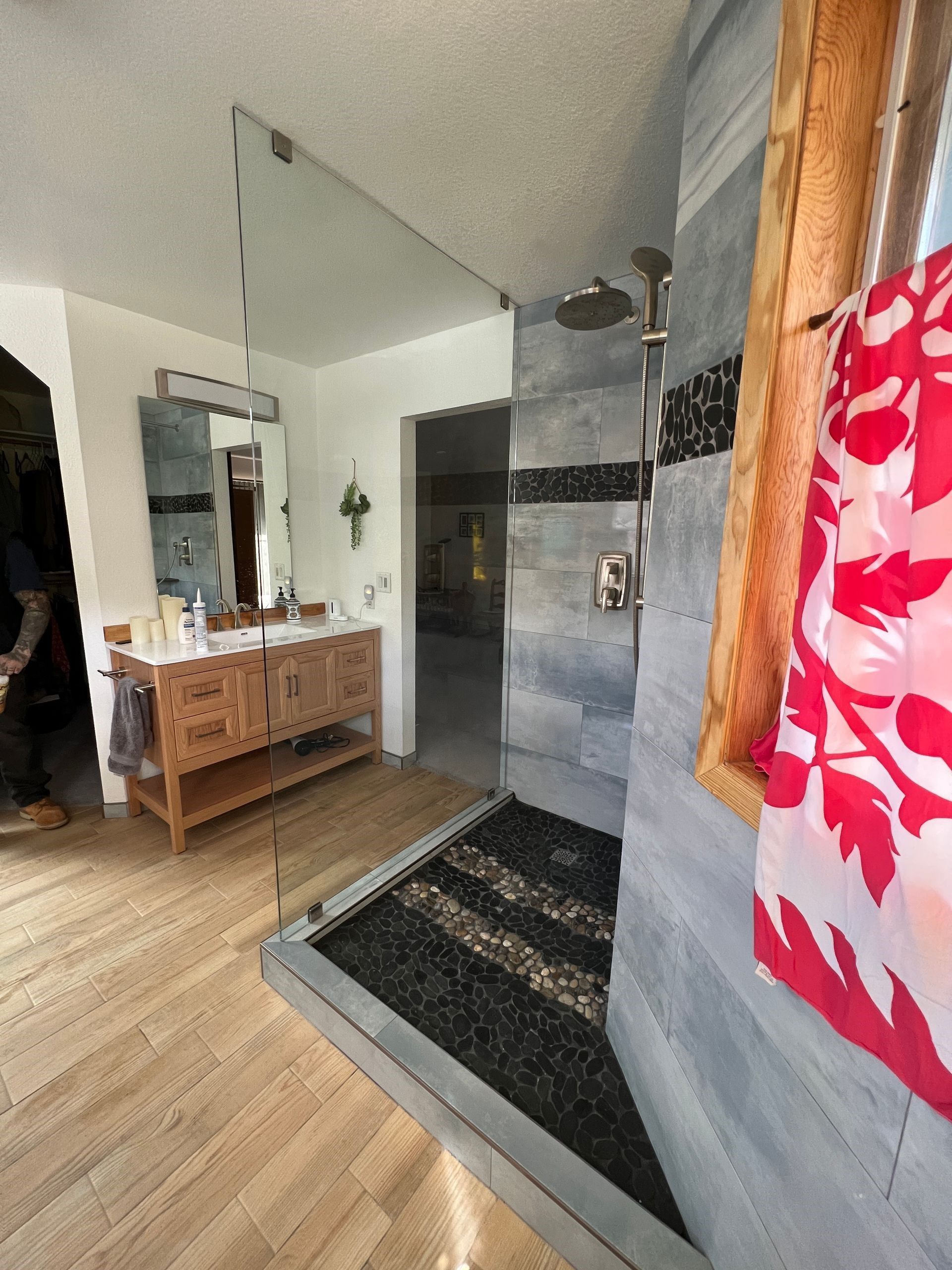 A bathroom shower with a glass partition