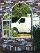 A white van is reflected in a mirror on a brick wall