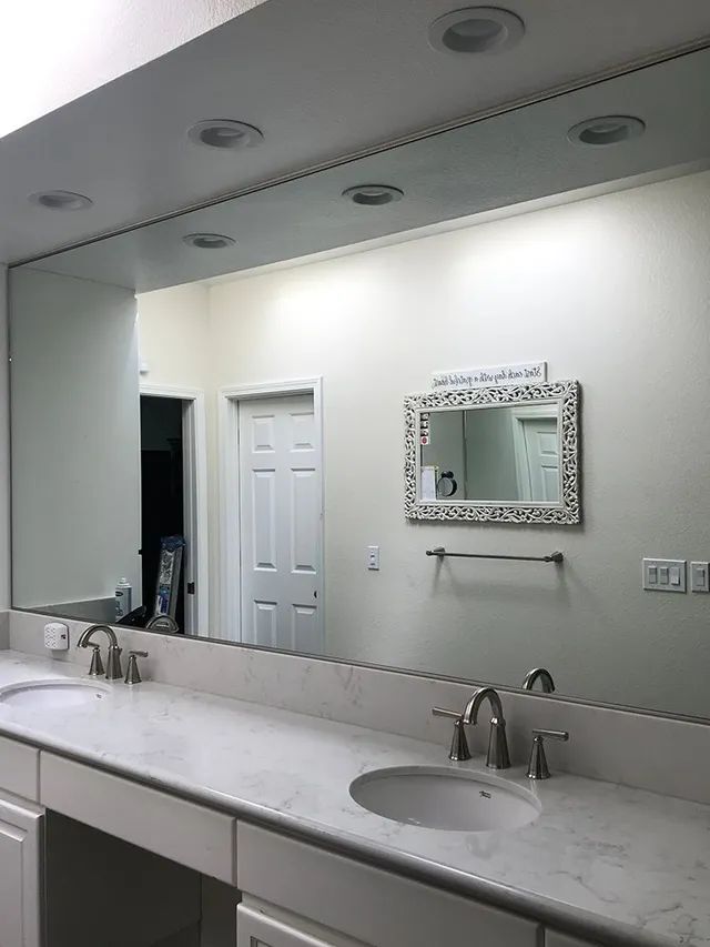 A bathroom with two sinks and a large mirror