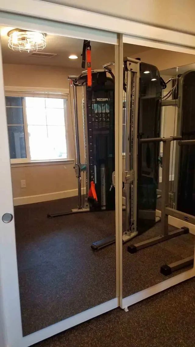 A gym with a lot of mirrors and a window