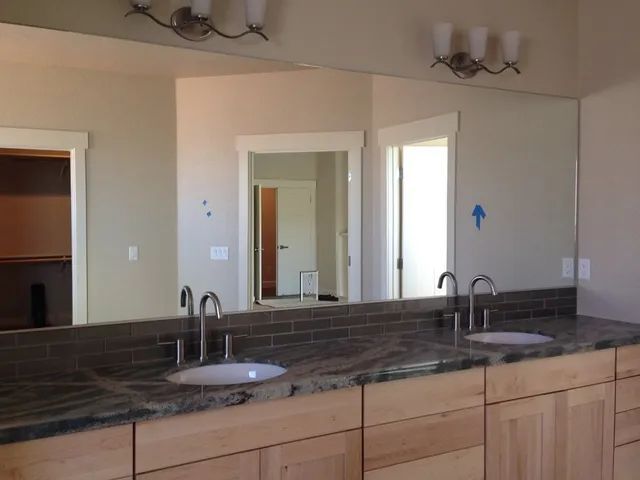 A bathroom with two sinks and a large mirror